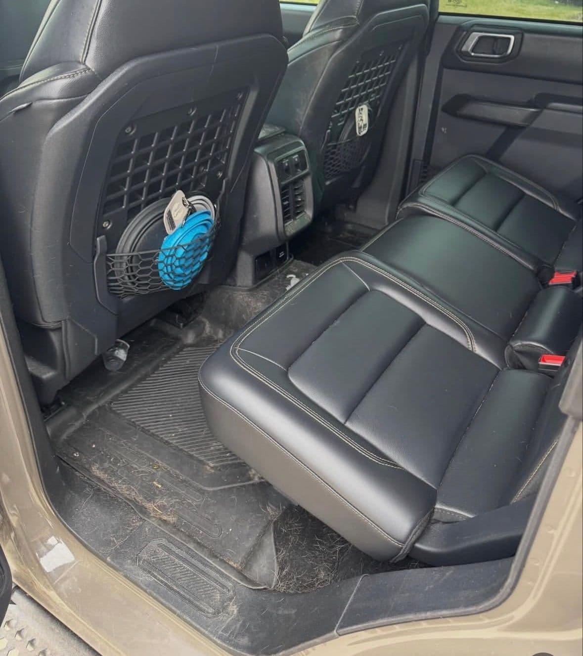 Ford Bronco rear seat area with dirt and debris on the floor before detailing.
