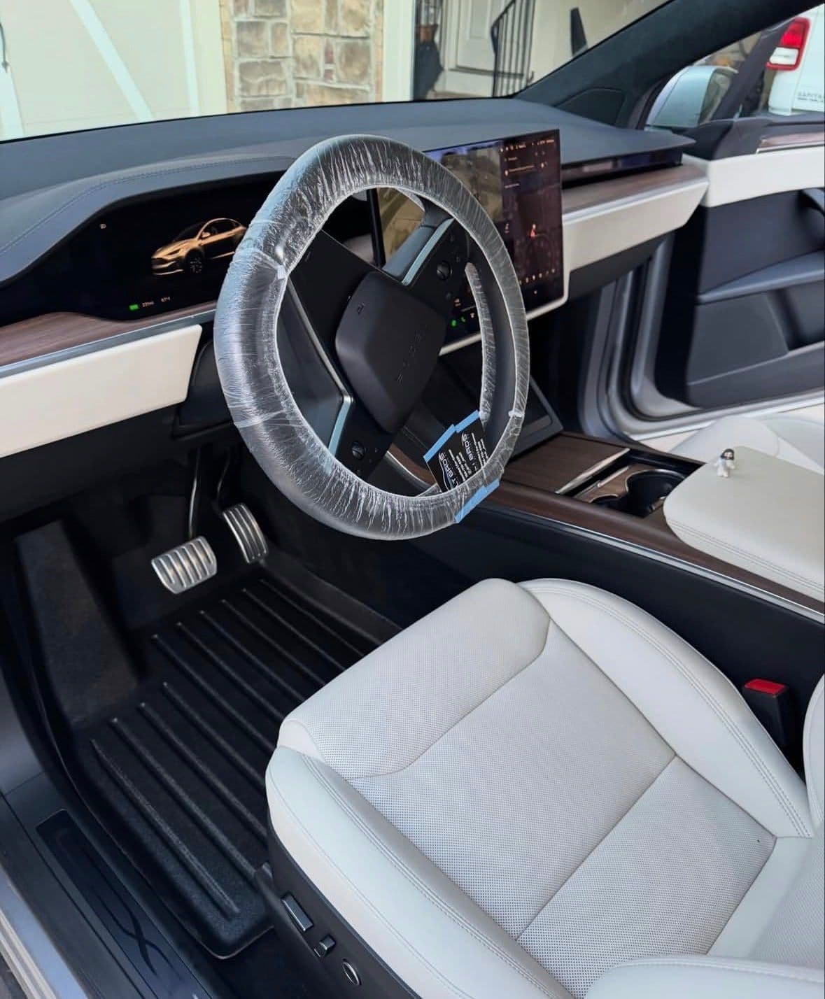 The same Tesla Model X footwell with a clean floor mat after detailing.